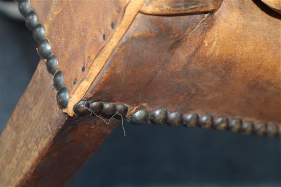 A George III mahogany hide-covered wing chair